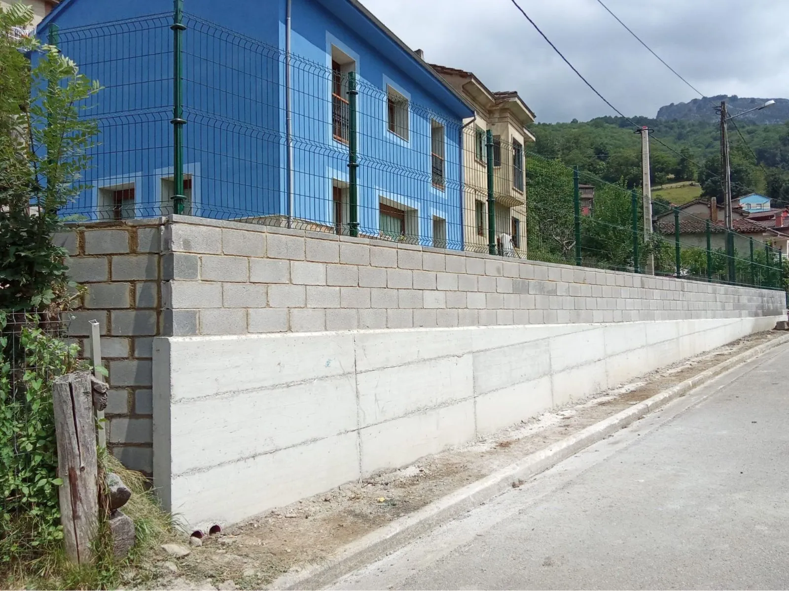Muro de contención de hormigón con bloque y cierre metálico